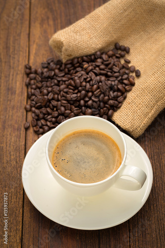 Coffee cup and coffee beans on wooden background