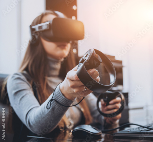 The beautifull girl playing games with virtual reality goggles