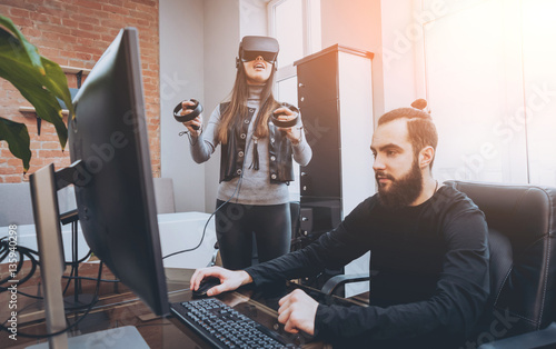 The young man with girlfriend plays a game at the office.