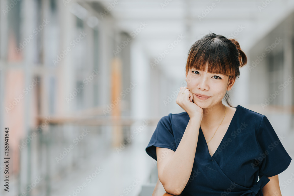 Portrait of young pretty happy Asian girl smiling inside building.