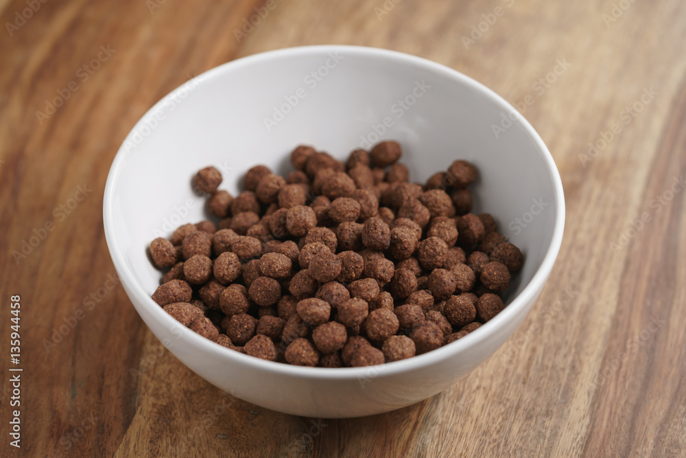 chocolate cereal balls in white bowl for breakfast, shallow focus chocolate cereal balls in white bowl for breakfast, shallow focus