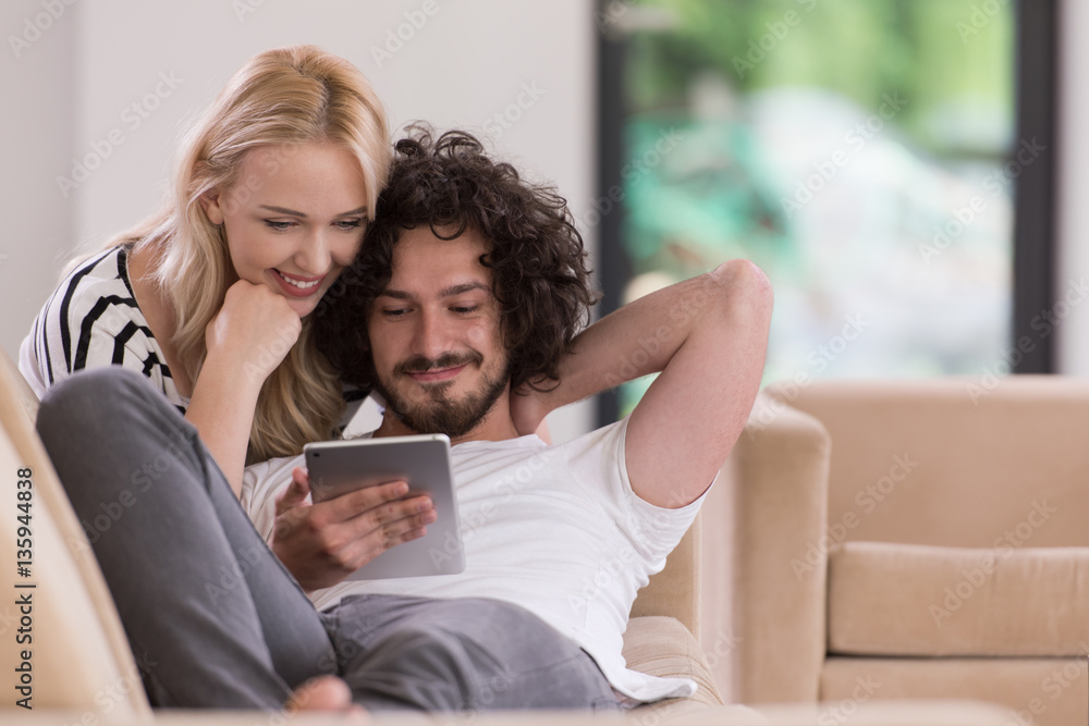 couple relaxing at home with tablet computers couple relaxing at home with tablet computers