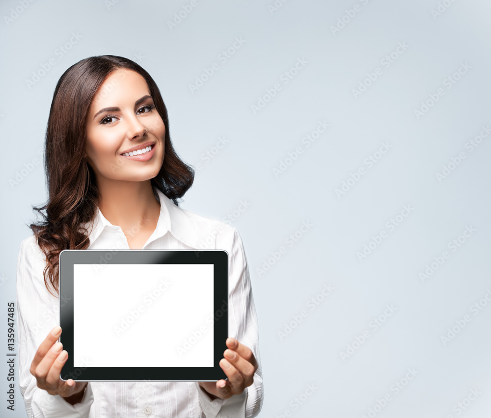Businesswoman showing blank tablet pc, on grey, with copyspace Businesswoman showing blank tablet pc, on grey, with copyspace