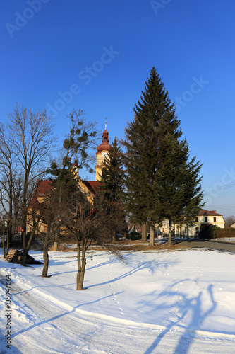 Kościół katolicki w zimowym krajobrazie.