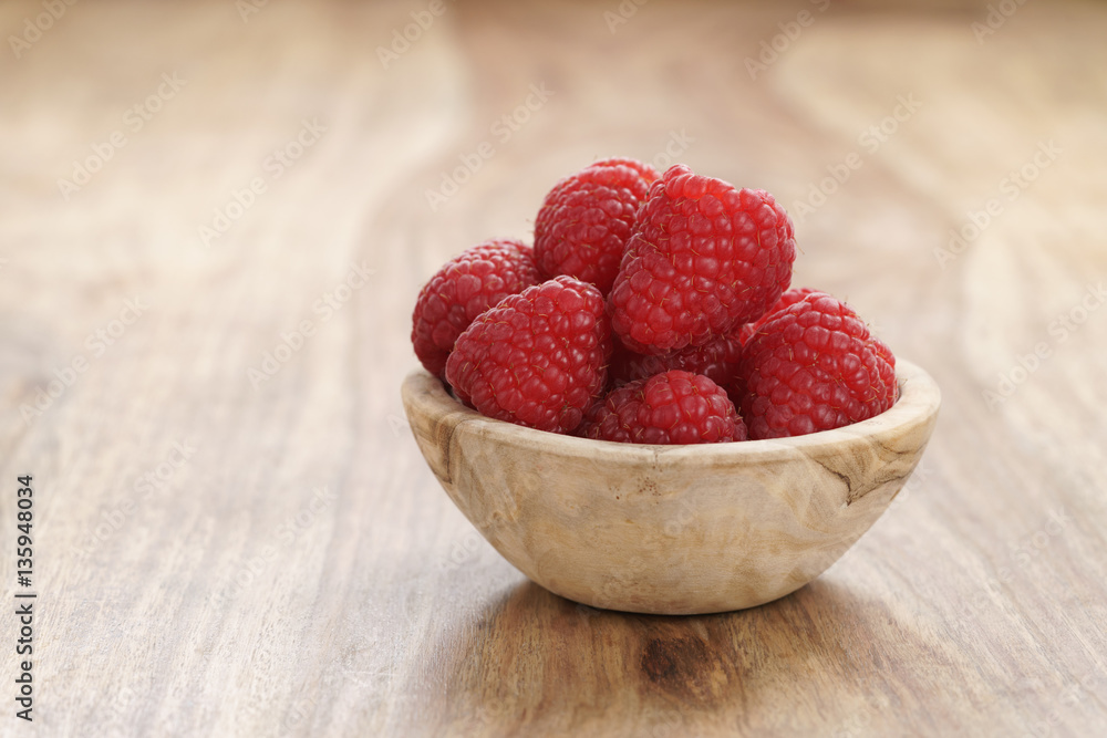 ripe organic raspberries in wood bowl on old wooden table, with copy space ripe organic raspberries in wood bowl on old wooden table, with copy space