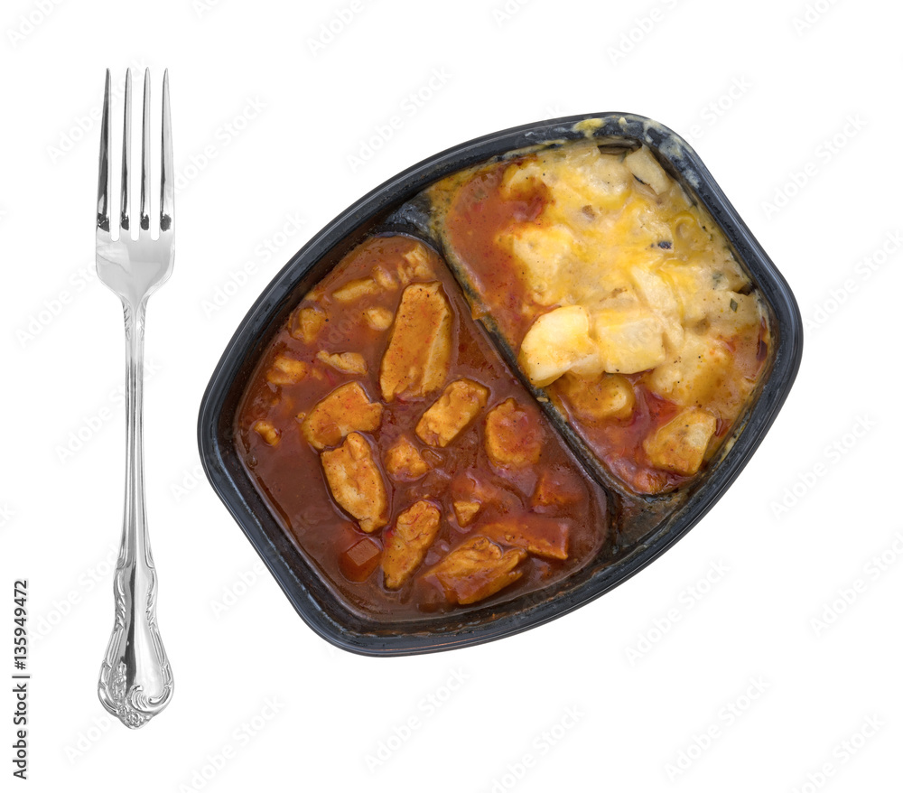 Φωτογραφία Top view of a microwaved TV dinner of chicken chunks in barbecue sauce plus potatoes and a fork to the side isolated on a white background