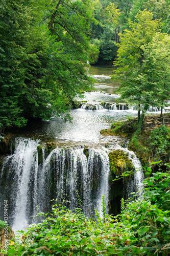 Fototapeta Naklejka Na Ścianę i Meble -  Beautiful forest cascade waterfall with clear, spring river wate