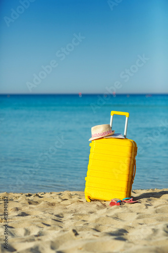 Travel holiday vacation suitcase with map, straw hat and beach s
