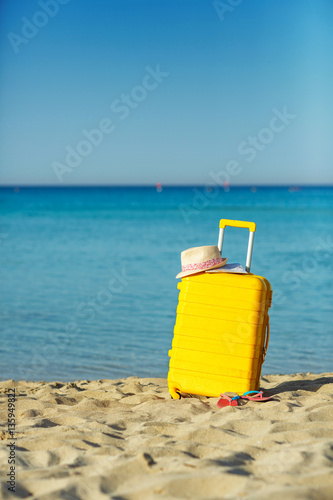 Travel holiday vacation suitcase with map, straw hat and beach s