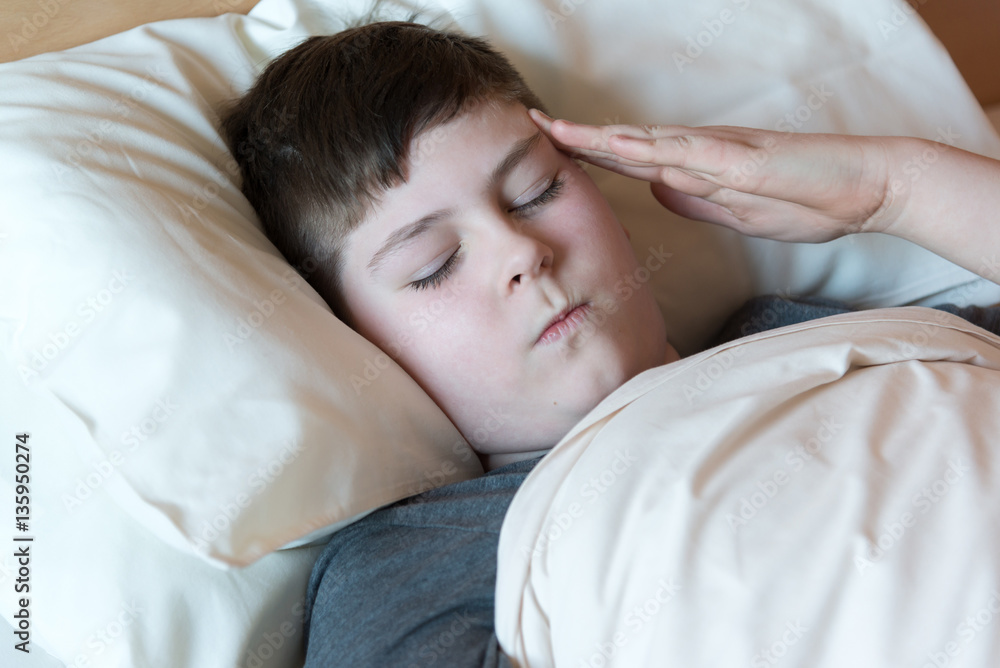 boy with headache lying in bed