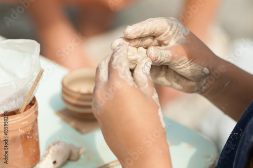 boy sculpts from clay toy closeup photo