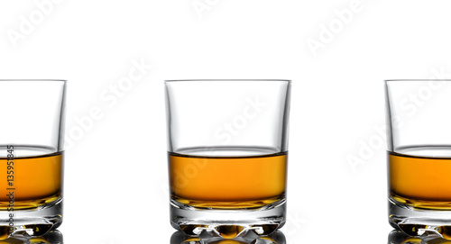 Three glasses of whiskey on a white background
