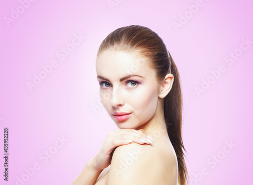 Portrait of young, beautiful and healthy woman: over violet background. Healthcare, spa, makeup and face lifting concept.