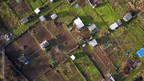 English garden allotments; vertical aerial rise drone