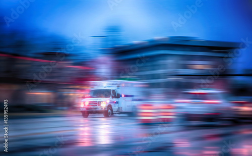an ambulance racing through the rain on a stormy night with moti photo