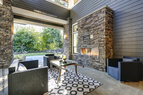 Print op canvas Well designed covered patio boasts stone fireplace