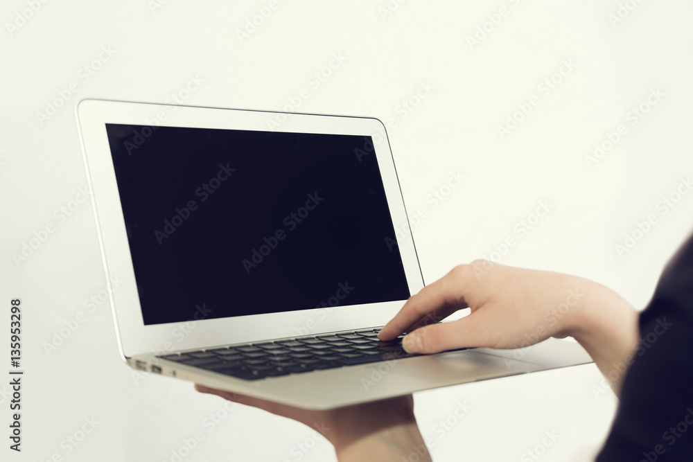 Businesswoman typing on a handheld laptop Businesswoman typing on a handheld laptop
