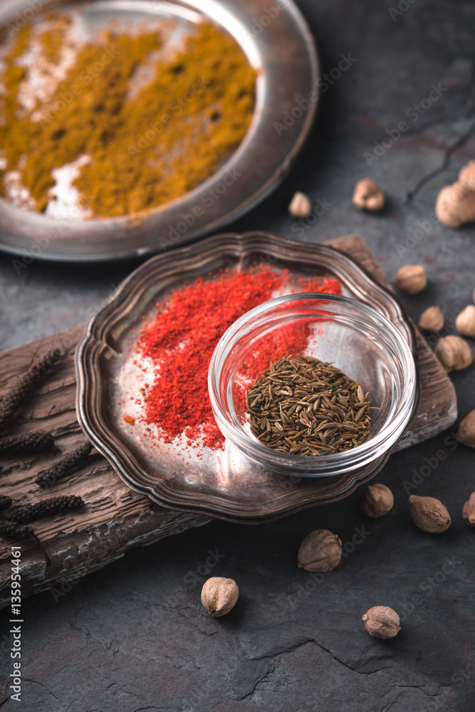 Cardamom, chilli, curry dishes on the stand on slate Cardamom, chilli, curry dishes on the stand on slate