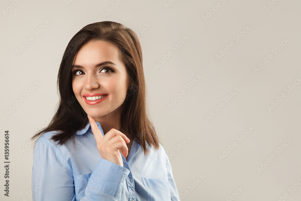Cheerful beautiful young business woman in blue shirt thinking Cheerful beautiful young business woman in blue shirt thinking