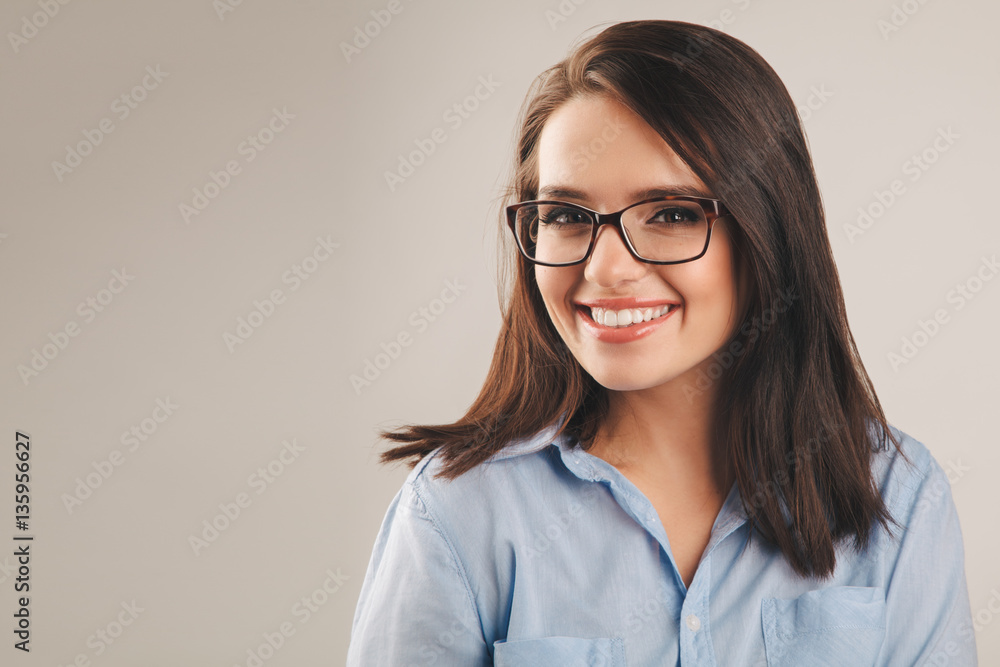 Cheerful beautiful young business woman in blue shirt with glass