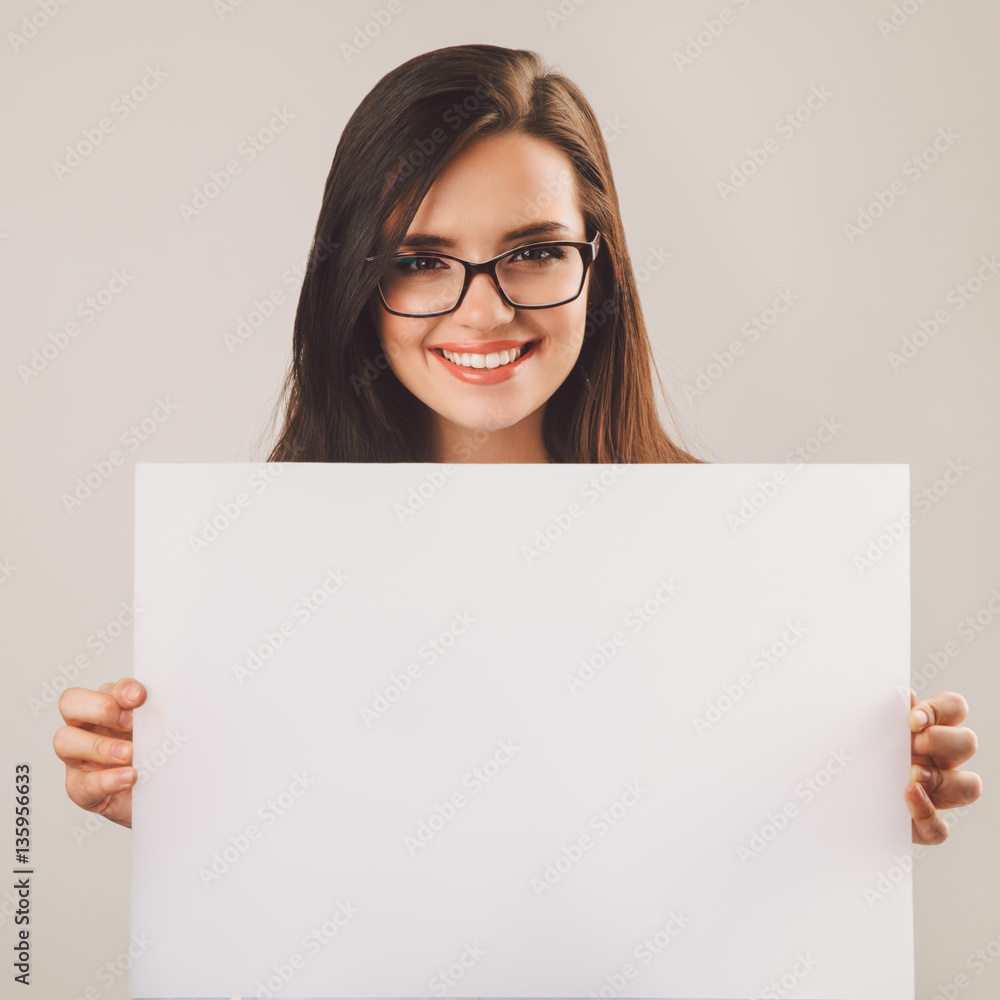 Young beautiful woman in glasses holding white blank board Young beautiful woman in glasses holding white blank board