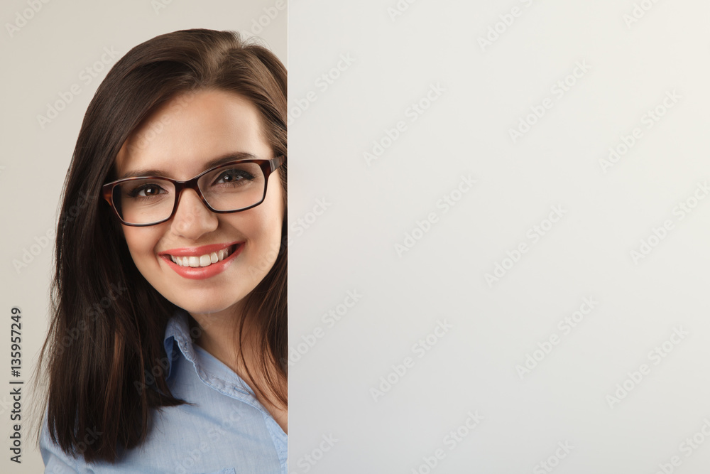 Young beautiful woman in glasses holding white blank board Young beautiful woman in glasses holding white blank board