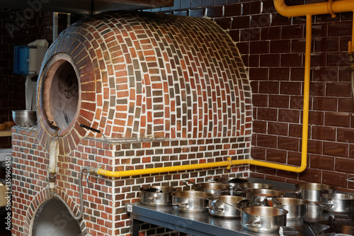 Foto Vertical gas heated tandoor oven in restaurant kitchen