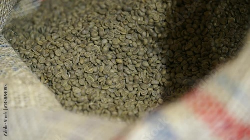 Scoop takenot roasted coffee beans from a bag at the factory. two views photo