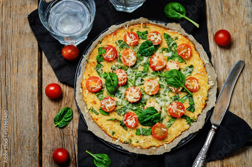 Cauliflower pizza crust with tomato and spinach photo