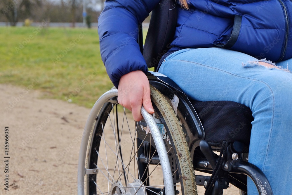 Fototapeta premium Main et roue de fauteuil roulant.