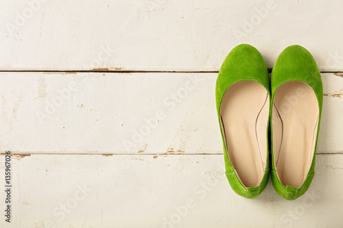Green women's shoes (ballerinas) on wooden background.