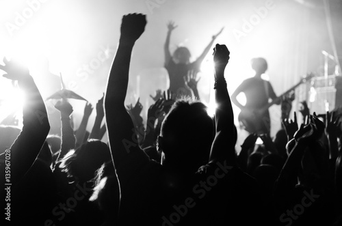 silhouettes of people at a concert in front of the scene in bright light