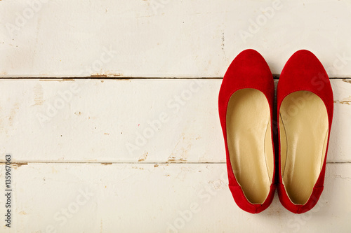 Red women's shoes (ballerinas) on wooden background.