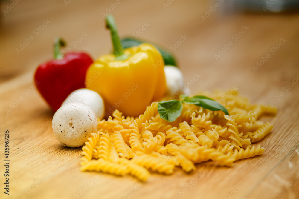fresh vegetables and pasta lying on a wooden table. fresh vegetables and pasta lying on a wooden table.