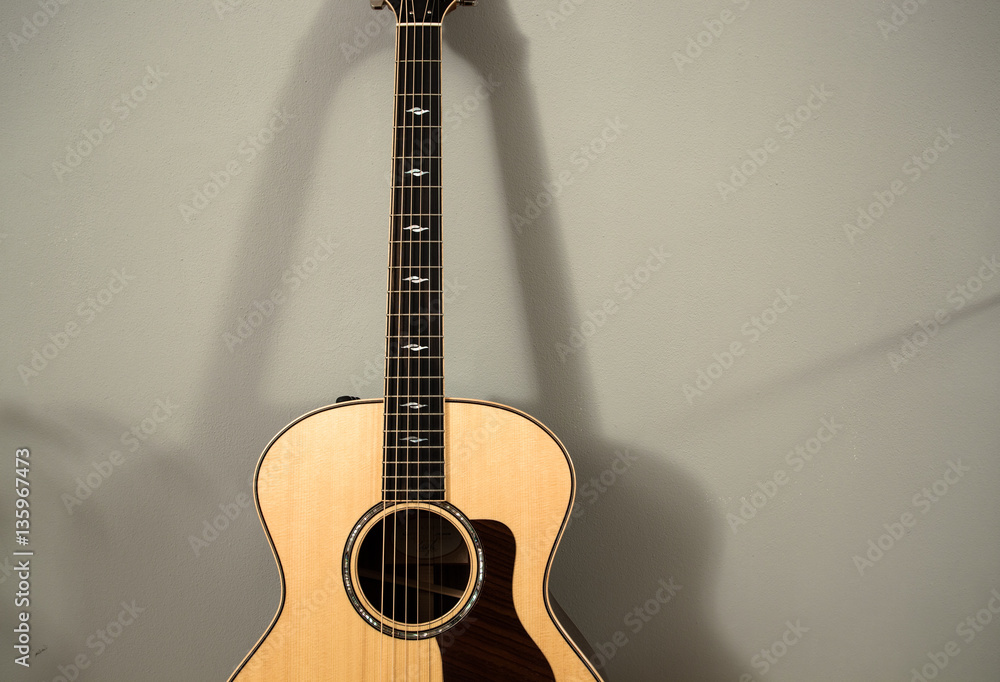 Fototapeta premium Acoustig guitar lying on the grey wall