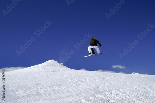 Snowboarder jump in terrain park at ski resort on sun winter day © BSANI