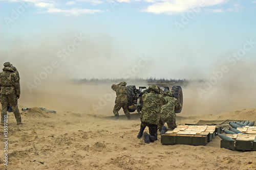 Military shooting from heavy artillery weapin photo