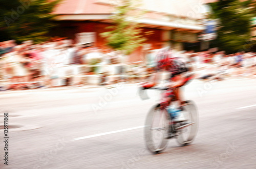 a person on a bicycle in a race held downtown in a city 