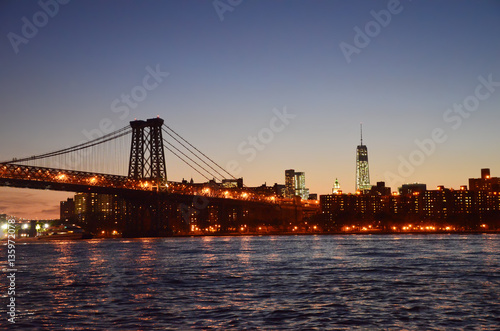 Brooklyn Bridge and Manhattan Skyline at Night with reflections in water