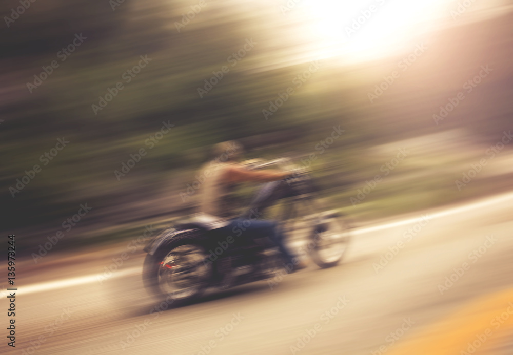 biker on mountain highway, riding around a curve with a motion b