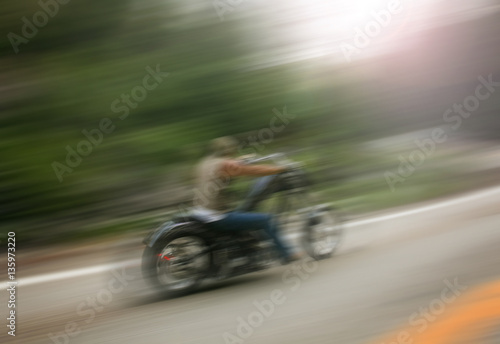 biker on mountain highway, riding around a curve with a motion b © annette shaff