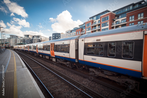 London Overground Service train passing at station