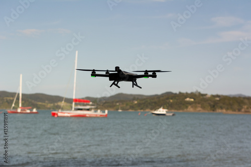 Drone flying with sailing boat in background