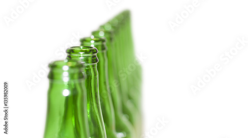 Row of open empty green bottles isolated on white background photo