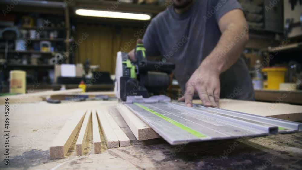 A craftsman is sawing a wooden bar. A concept of master class. Real time shot A craftsman is sawing a wooden bar. A concept of master class. Real time shot