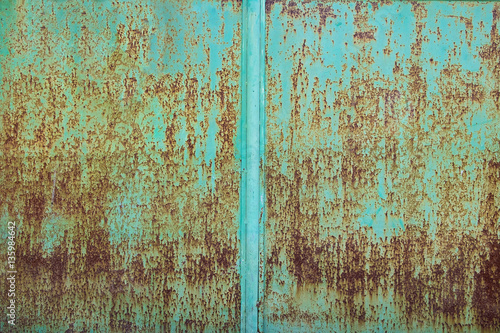Green paint peeling off a metal plate, background.