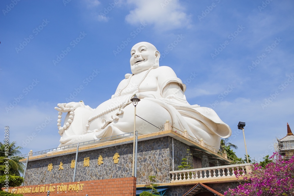 Fototapeta premium Maitreya Buddha statue located in the famous Vinh Trang pagoda in My Tho city, Tien Giang province, Vietnam.