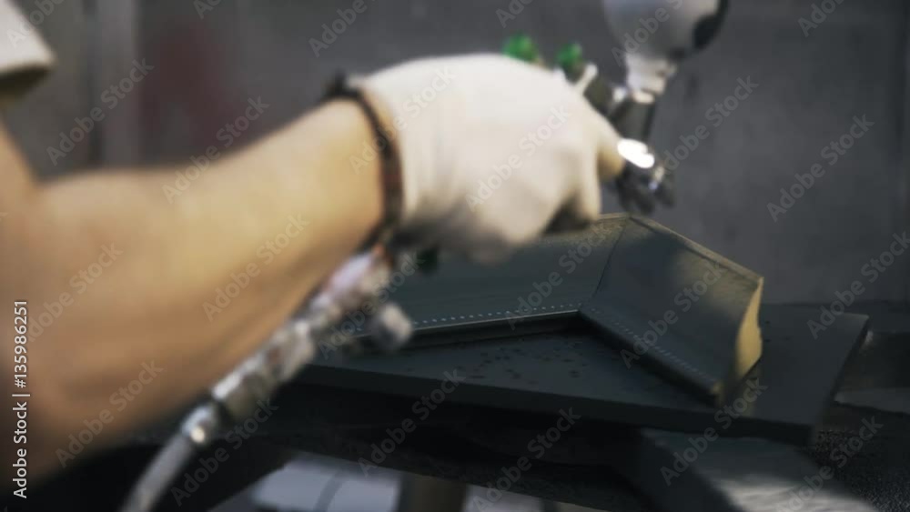 Carpenter is processing a sample of frame for canvas using black paint. Real time shot. a concept of a workshop. Carpenter is processing a sample of frame for canvas using black paint. Real time shot. a concept of a workshop.
