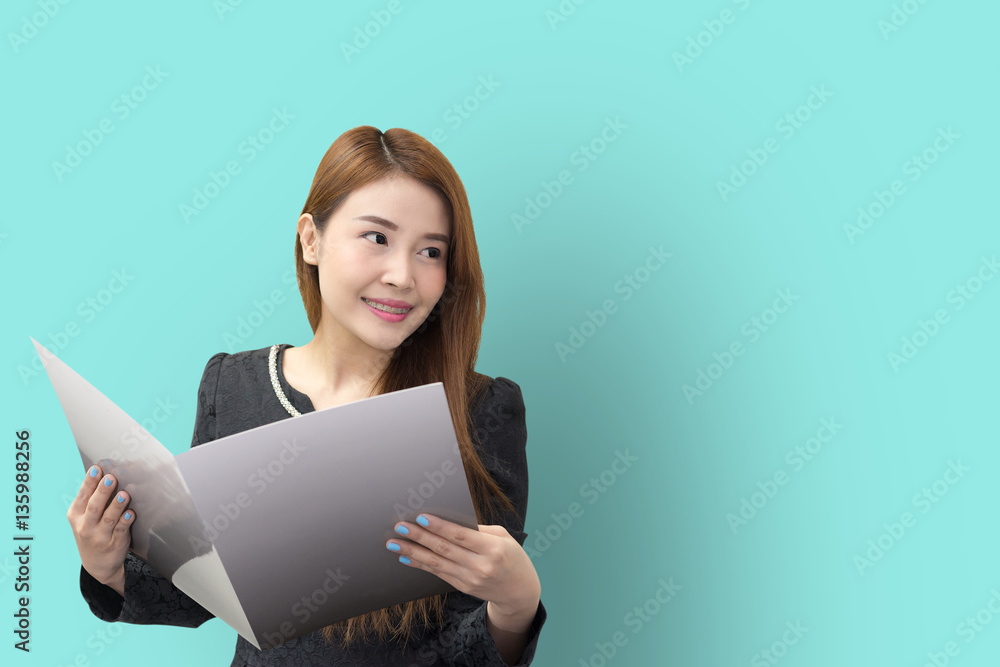 The pretty Asian business women open the file with the light green background The pretty Asian business women open the file with the light green background