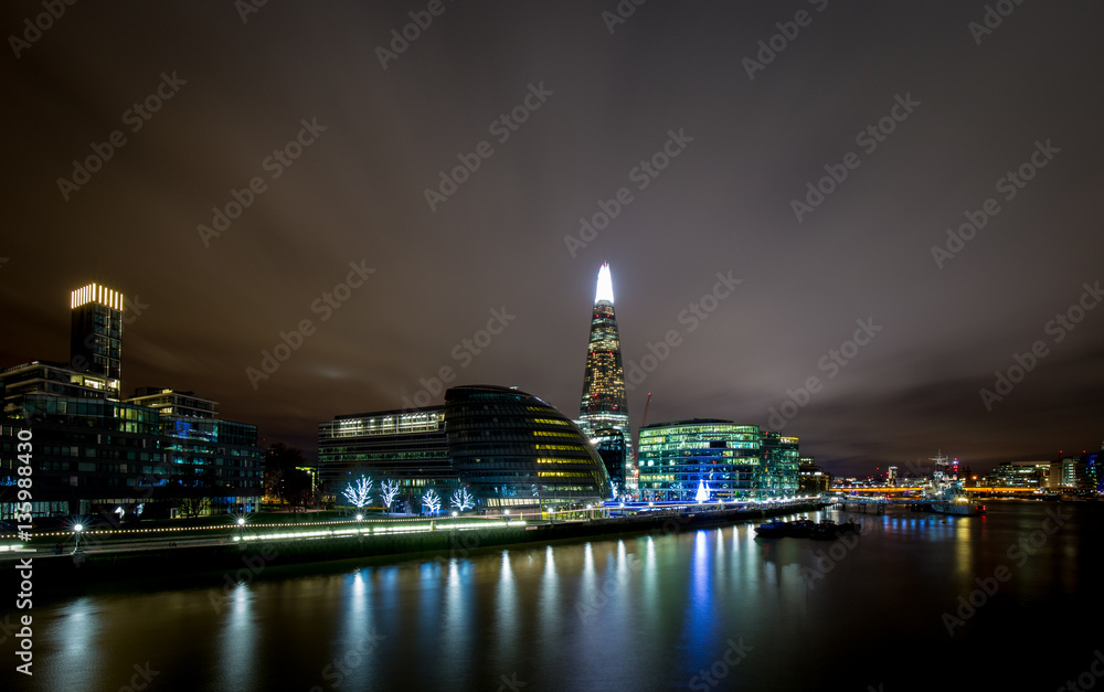 Illuminated night skyline of More London and the city hall along